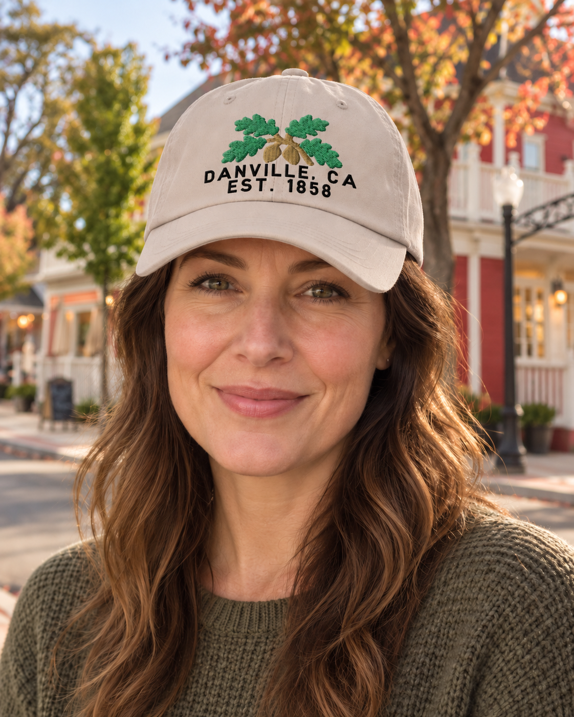 Digital lifestyle visualization of an adult wearing the Stone Danville Oak embroidered cap against an adapted Hartz Avenue backdrop.