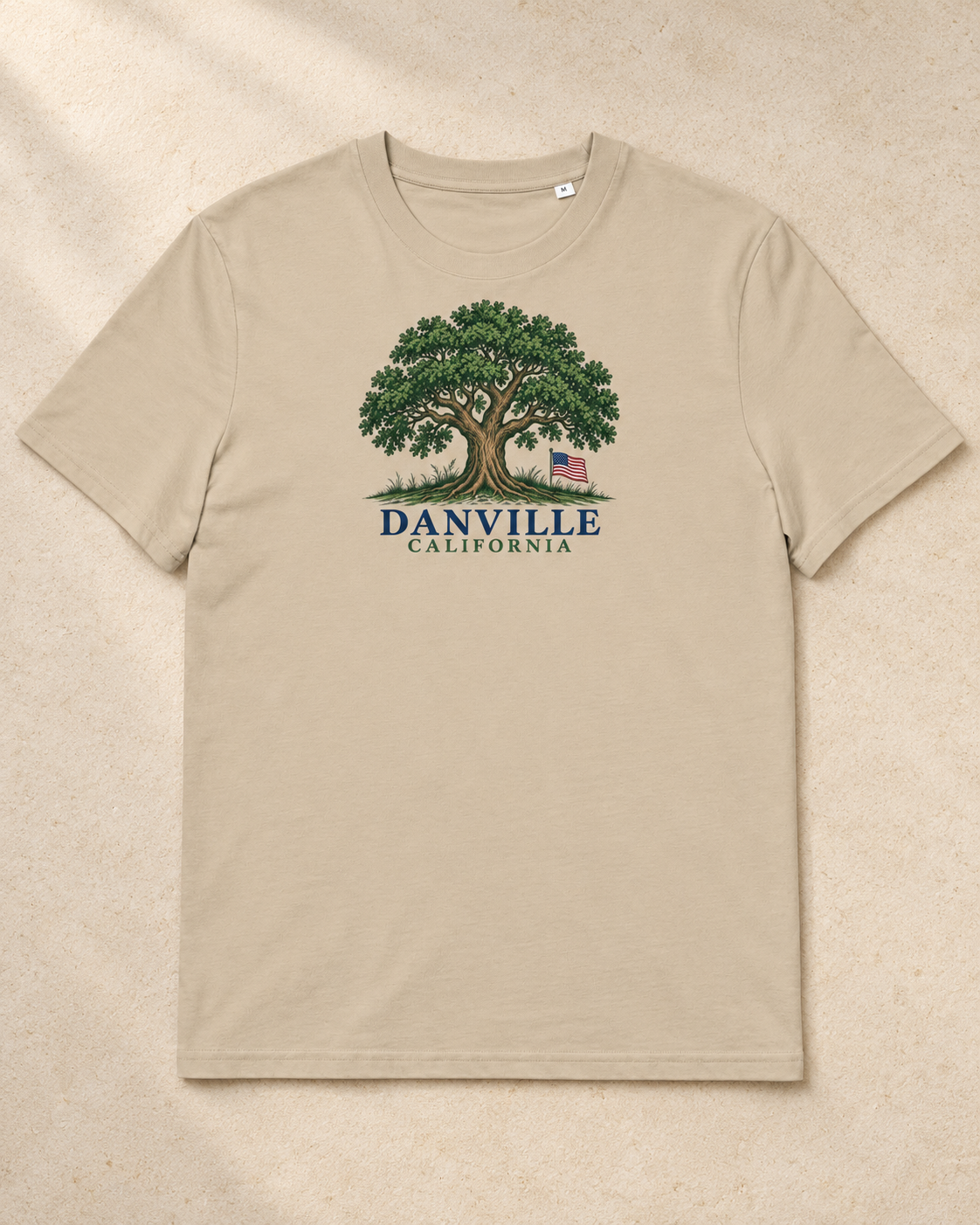 Danville Oak & Flag | Organic Tee — full product on warm textured stone with soft natural shadows.